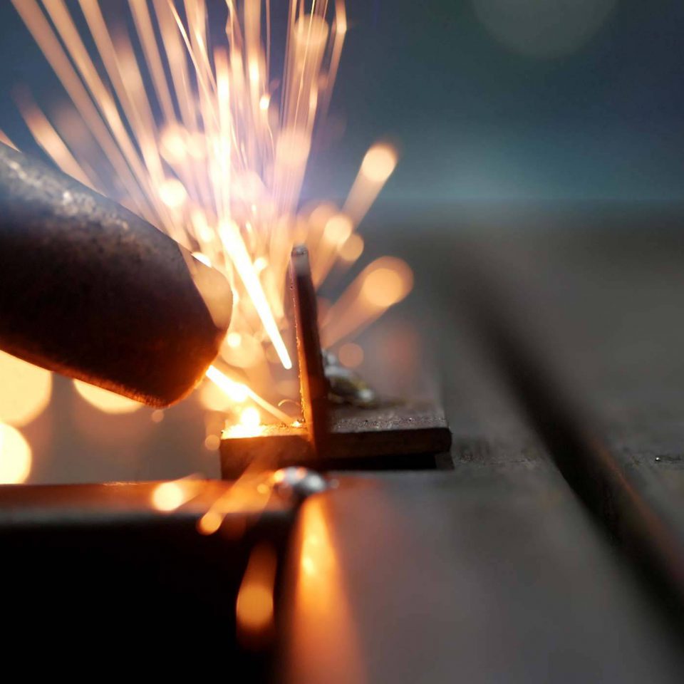 tip of welding gun creating custom metal fabrication