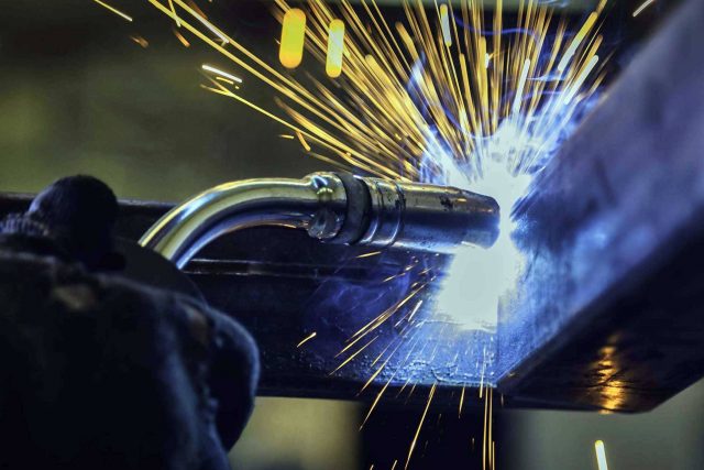 hands welding a custom metal fabrication